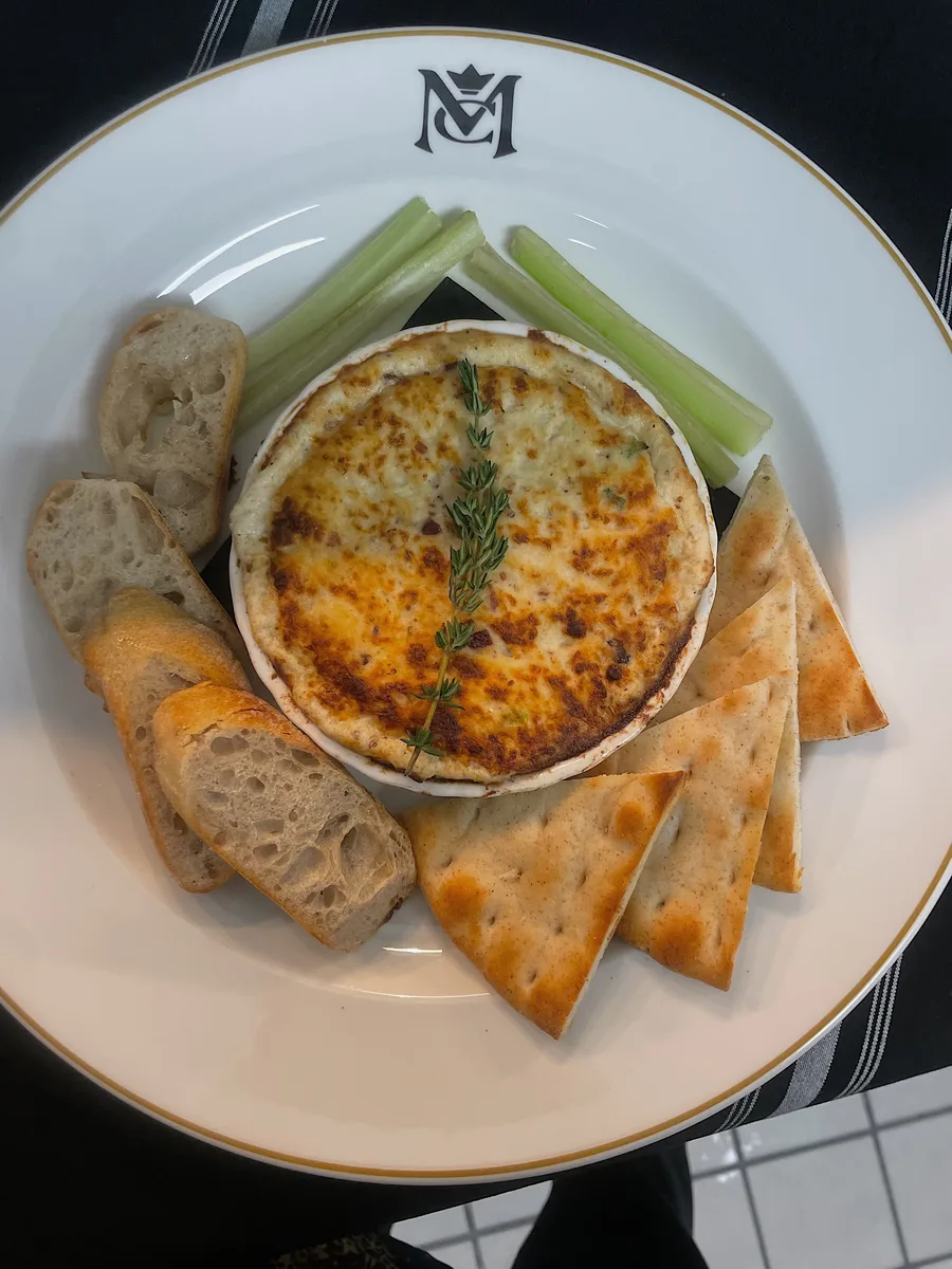 A warm baked dip served with bread and crackers