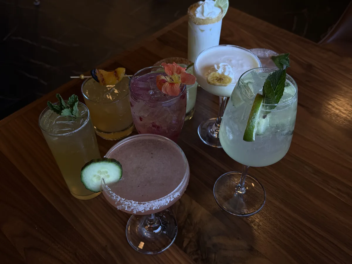 A selection of colorful cocktails on a wood table