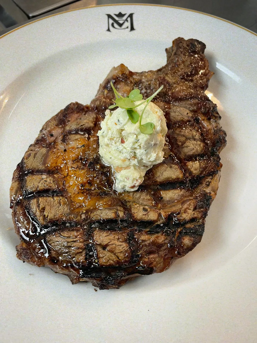 A grilled ribeye topped with herb butter